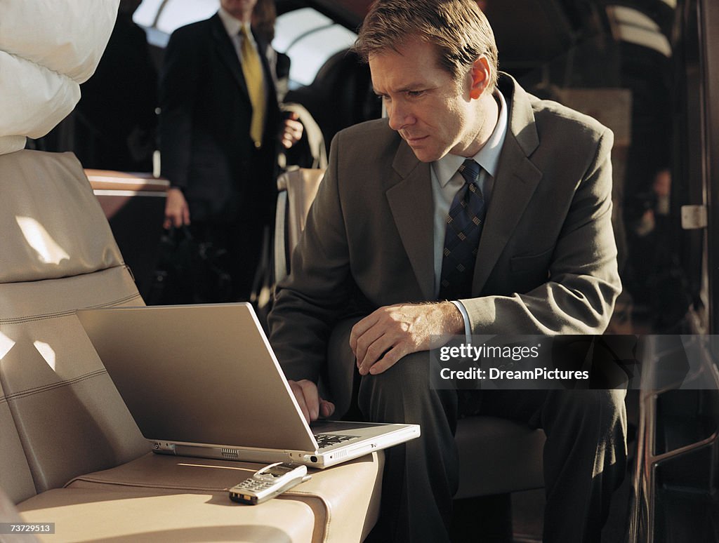 Businessman using laptop while riding on commuter train