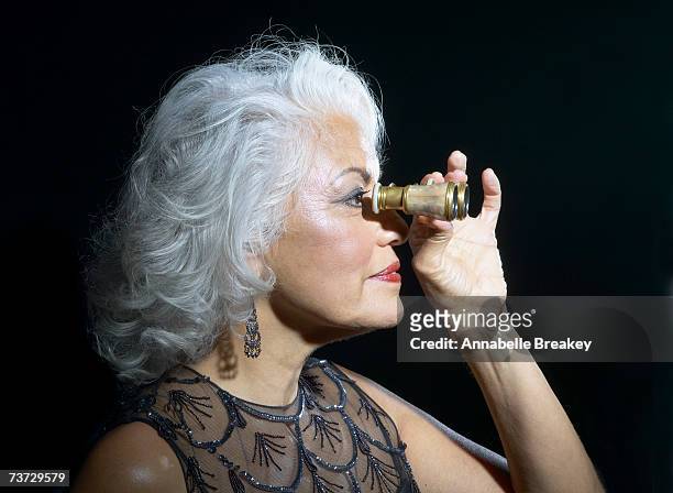 woman looking through opera glasses, profile - binocolo da teatro foto e immagini stock