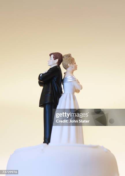 bride and groom figurines on cake top back to back - bruidstaart stockfoto's en -beelden