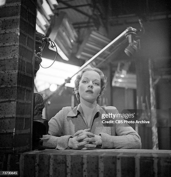 German-born television actress Maria Riva, daughter of Marlene Dietrich, leans on a false brick wall in a television studio during the production of...