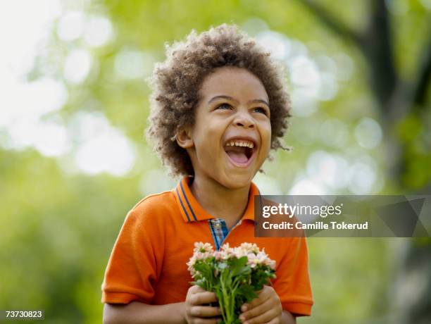 boy (3-5) holding flower, laughing - flower arrangement stock pictures, royalty-free photos & images