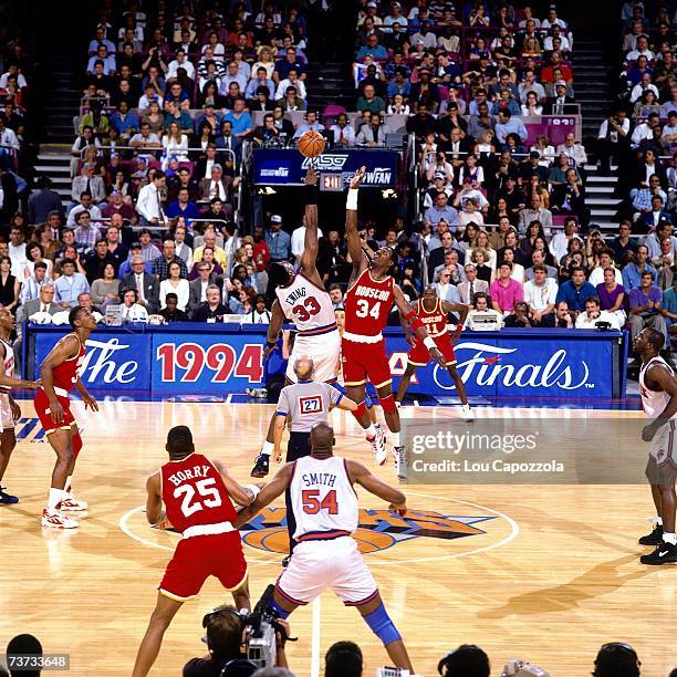 Patrick Ewing of the New York Knicks battles Hakeem Olajuwon of the Houston Rockets for the opening tip during game five of the 1994 NBA Finals...