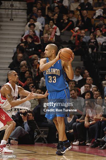 Grant Hill of the Orlando Magic looks to move the ball against Juan Dixon of the Toronto Raptors during the game at Air Canada Centre on March 21,...