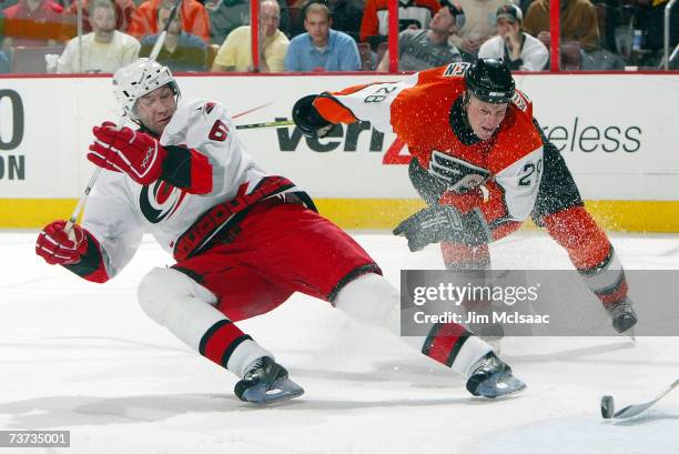 Erik Cole of the Carolina Hurricanes is hooked off the puck by Lasse Kukkonen of the Philadelphia Flyers during their game on March 28, 2007 at the...