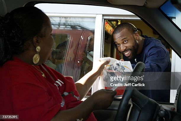 Golden State Warriors' Baron Davis gives away game tickets along with food order to a fan at the drive-thru window of McDonald's March 28, 2007 in...