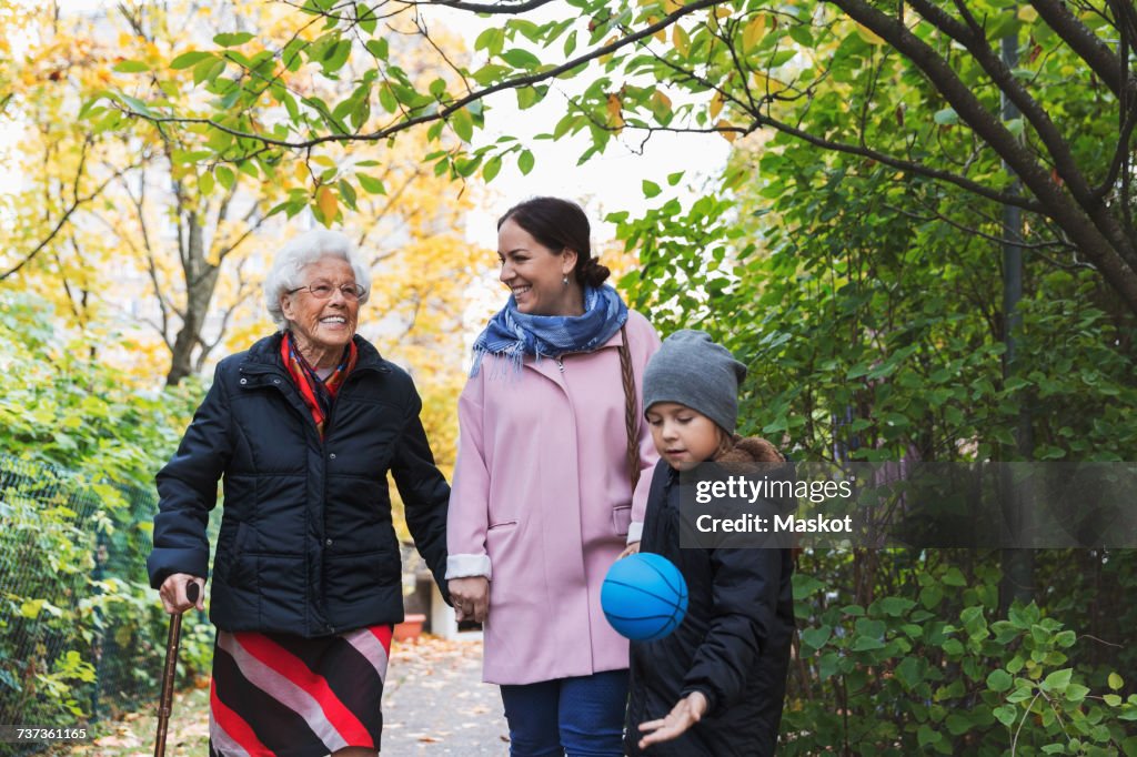 Happy senior woman with daughter and great grandson in park