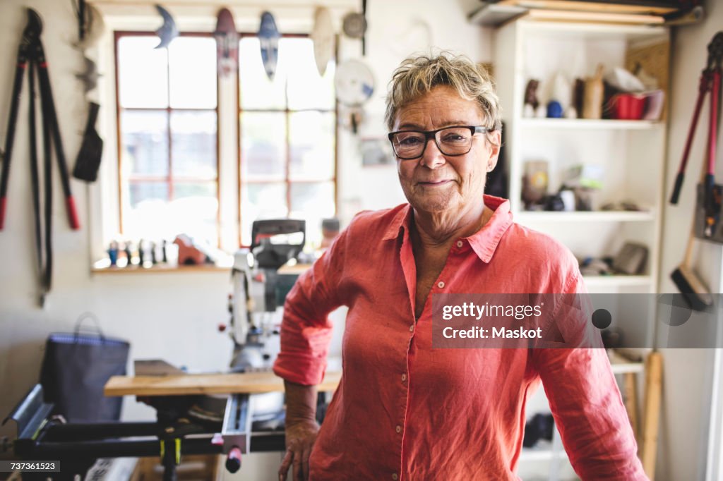 Portrait of confident senior woman standing in workshop