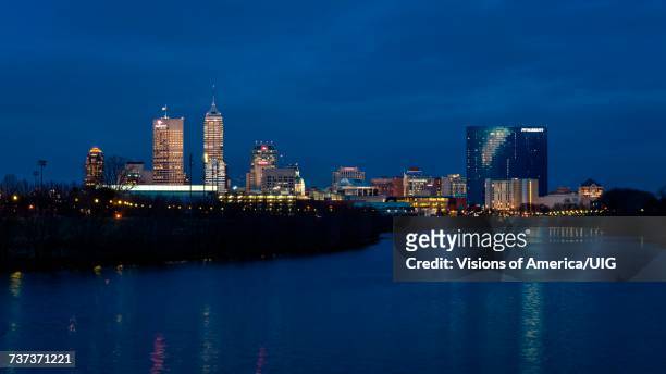 indianapolis state capitol and skyline at dusk along white river state park - indiana skyline stock pictures, royalty-free photos & images