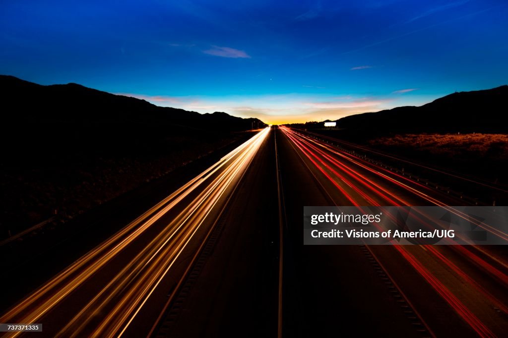 Streaked lights at sunset over Interstate 15, Nevada at sunset