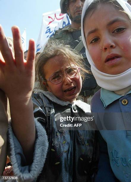 Iraqi girls cry the arrest of their father during a protest condemning military raids in Baghdad's al-Ghazaliyah neighborhood, 29 March 2007....