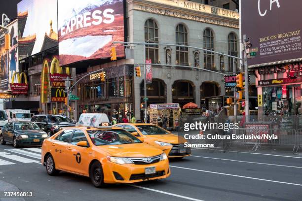 yellow cabs and shop fronts, times square, new york city, usa - taxi amarillo fotografías e imágenes de stock