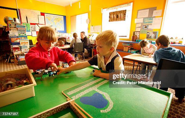 Teacher Ray Felstead teaches in the background as Adam Dickson plays with a school mate at the North Arm school on February 7, 2007 in the Falkland...