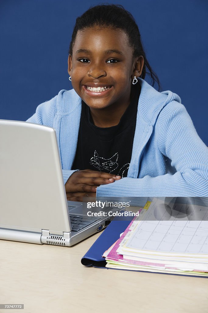 Young woman with laptop, smiling, portrait