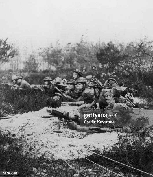 Soldiers from a Canadian regiment waiting for enemy action in a narrow trench on the Western Front, 10th February 1945.