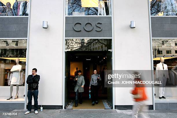 People leave Berlin's new COS store which opened on famed Ku'Damm avenue 30 March 2007. A brainchild of Swedish retail clothing giant HM, COS is...