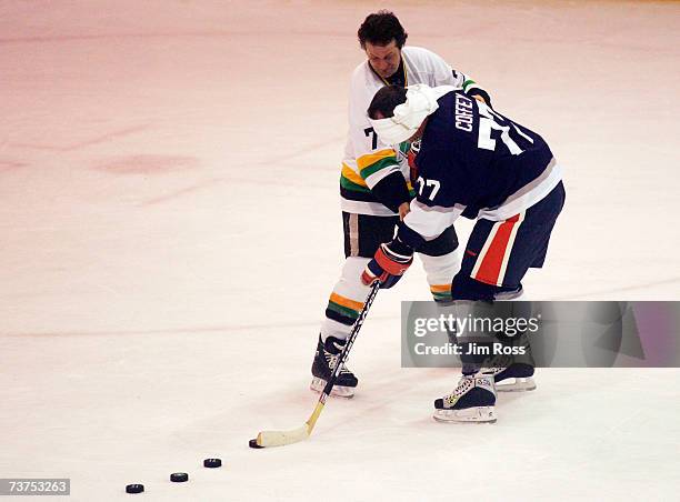 Blue Rodeo's Jim Cuddy helps out ex-NHL player Paul Coffey who he blind folded to where to shoot during a skills competition at the Juno Cup hockey...