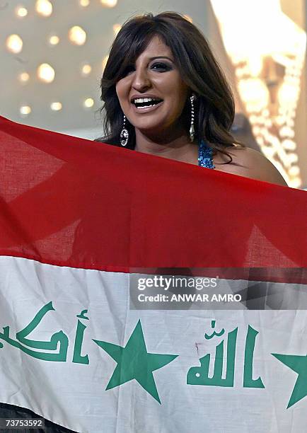 Iraqi Shatha Hassun holds up her national flag after winning the pan-Arab Star Academy reality talent show and competition, in Adma, north of Beirut...