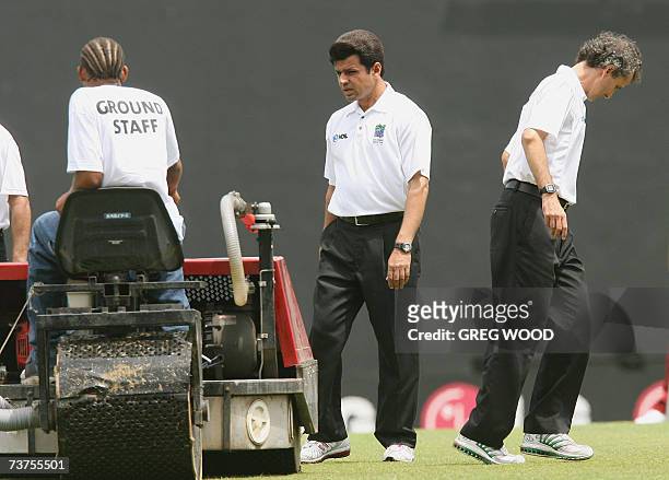 St John's, ANTIGUA AND BARBUDA: CAPTION CORRECTION - UMPIRE'S NAME Umpires Aleem Dar and Billy Bowden check the condition of the outfield prior to...