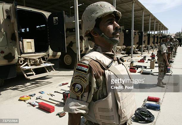 An Iraqi soldier stands next to new equipment and Badger armored vehicles at Taji military base March 31, 2007 in Baghdad, Iraq. Soldiers from the...