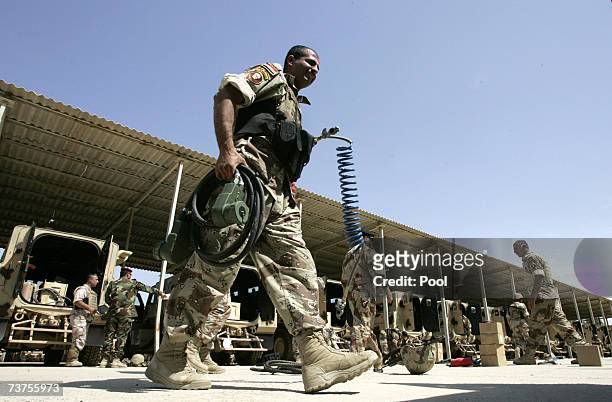 An Iraqi soldier carries equipment for new Badger armored vehicles at Taji military base March 31, 2007 in Baghdad, Iraq. Soldiers from the 1st...
