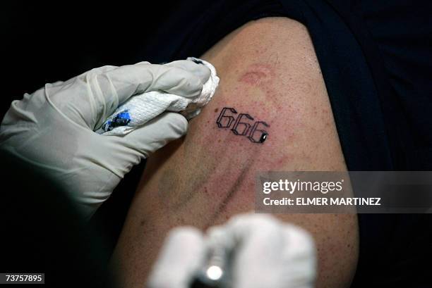 Tegucigalpa, HONDURAS: A man gets a tattoo with the number 666, in Tegucigalpa, 31 March 2007, following the spiritual leader of "Growing in Grace",...