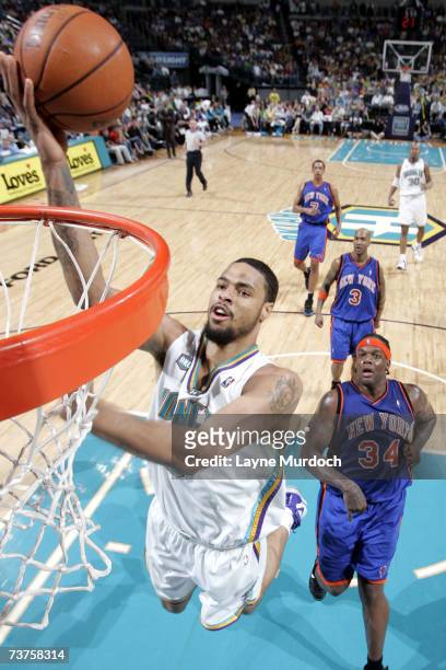 Tyson Chandler of the New Orleans/Oklahoma City Hornets lays the ball up against Eddy Curry of the New York Knicks during a game at the Ford Center...