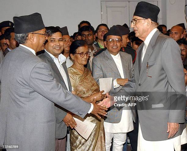 Nepalese Prime Minister Girija Prasad Koirala shakes hands with Education and Sports Minister Pradeep Nepal CPN-UML, after taking an oath of office...