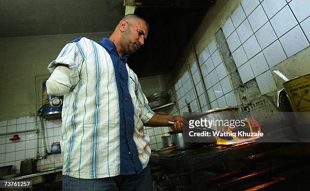 Fuad Mosa Muhammad, age 40, works at a restaurant April 1, 2007 in Baghdad, Iraq. Fuad, a cook at a breakfast and lunch restaurant, was injured and...