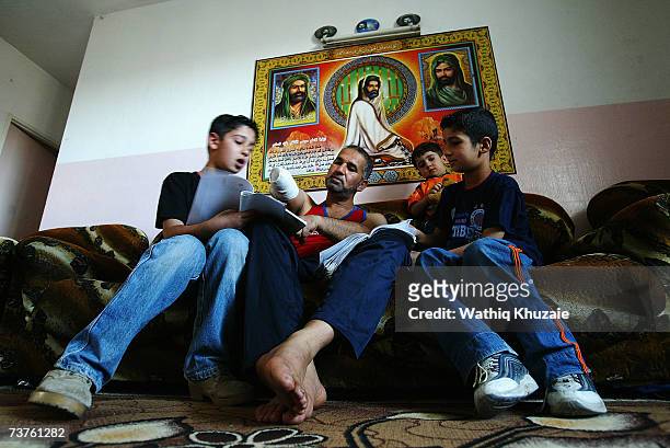 Fuad Mosa Muhammad , age 40, teaches his sons at his house on March 28, 2007 in Baghdad, Iraq. Fuad, a cook at a breakfast and lunch restaurant, was...