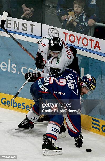 Blake Sloan of Adler Mannheim challenges Ivan Ciernik of Cologne Haie during their DEL play off half final Bundesliga match in the SAP Arena on April...