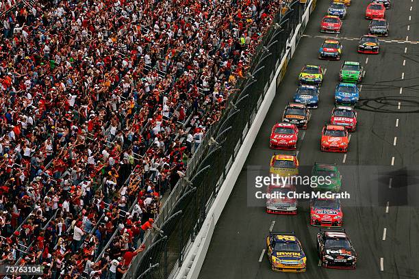 Denny Hamlin, driver of the FedEx Express Chevrolet, and Jamie McMurray, driver of the Irwin Industrial Tools Ford, lead the field into turn one at...