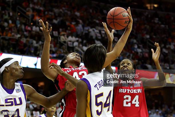 Rashidat Junaid of the Rutgers Scarlet Knights attempts to control a rebbound against Ashley Thomas and Sylvia Fowles of the LSU Lady Tigers during...