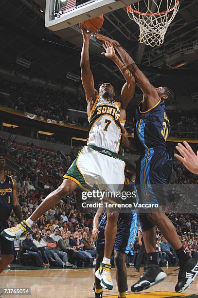 Rashard Lewis of the Seattle SuperSonics goes to the basket against the defense of Nene of the Denver Nuggets on APRIL 1, 2007 at the Key Arena in...