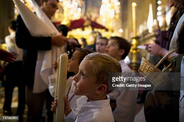 Child, members of 'La Borriquita' brotherhood waits to understand if their procession will be cancelled due to the weather in The Church of La...