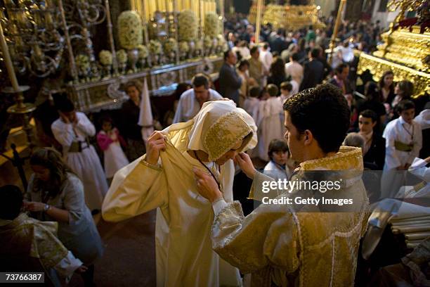 Members of 'La Borriquita' brotherhood prepares themselves as they wait to understand if their procession will be cancelled due to the weather in The...