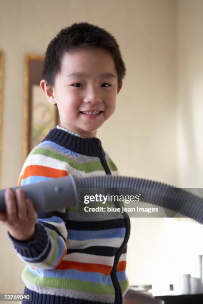 smiling boy holding vacuum cleaner pipe. - pipe cleaner stock pictures, royalty-free photos & images