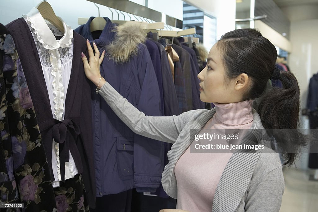 Young woman compares blouses while shopping