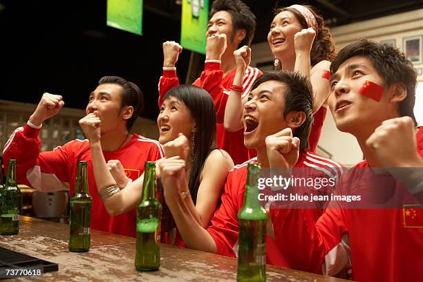 group of friends breathes a sigh of relief after an intense play at a sports bar - beer bottle mouth stock-fotos und bilder