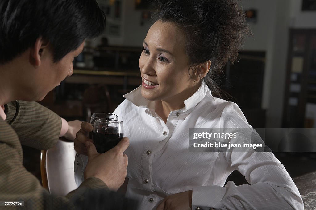 A couple makes a toast at a bar