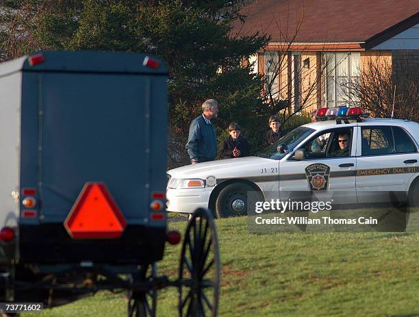 Amish children pass Pennsylvania State Troopers as they head to their newly built schoolhouse April 2, 2007 in Nickel Mines, Pennsylvania. The school...