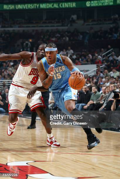 Carmelo Anthony of the Denver Nuggets drives against Luol Deng of the Chicago Bulls during the game at the United Center on March 22, 2007 in...