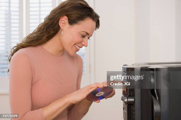 hispanic woman putting cd into stereo - cd player stock pictures, royalty-free photos & images