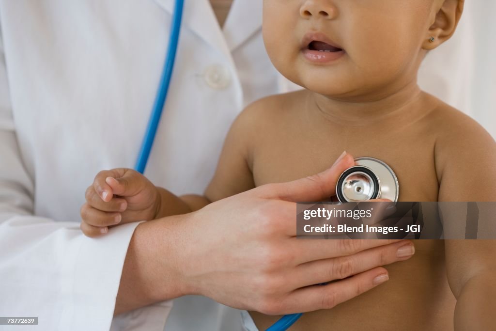 Hispanic baby being examined by doctor