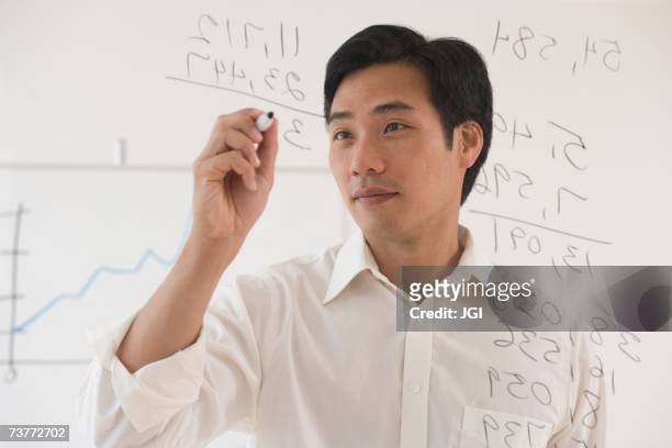 asian businessman writing on white board - expertise niveau scolarisation apprentissage concepts photos et images de collection