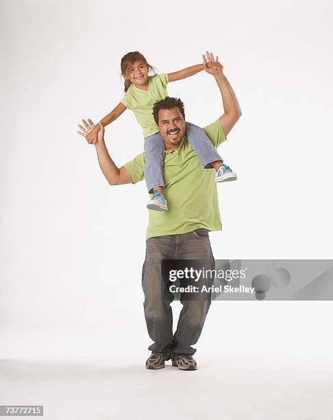 studio shot of hispanic father holding daughter on shoulders - friends studio shot stock pictures, royalty-free photos & images