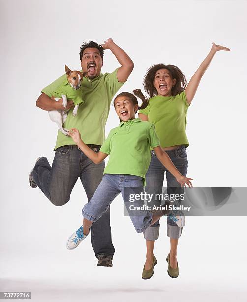 studio shot of hispanic family jumping - one in three people stock pictures, royalty-free photos & images