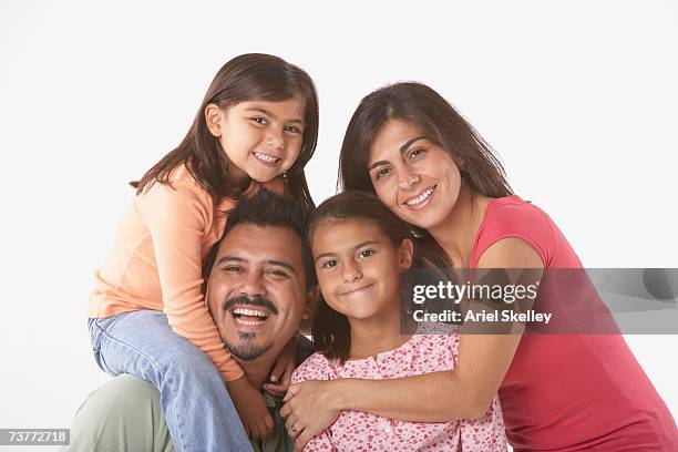 studio shot of hispanic family hugging - family studio shot stock pictures, royalty-free photos & images