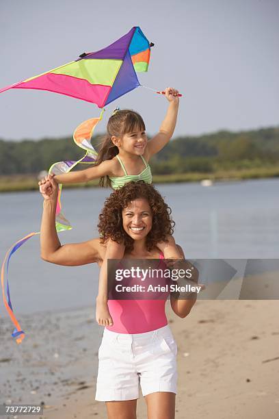 hispanic mother and daughter flying kite on beach - hot latino girl stock pictures, royalty-free photos & images