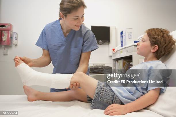 nurse assisting boy with broken leg - leg cast hospital stock pictures, royalty-free photos & images