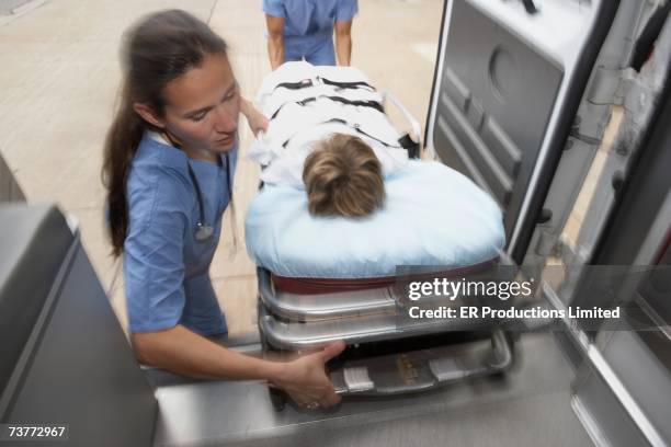 blurred motion shot of doctors unloading patient from ambulance - ambulance arrival stock pictures, royalty-free photos & images